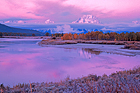 Icy blue pool in Winter with snowy mountain peak in the background