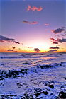 Sunset over foamy ocean waves