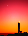 Lighthouse at sunset with moon overhaed