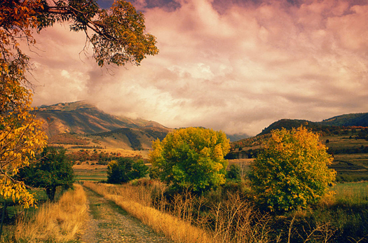 A dirt road in the country and mountain