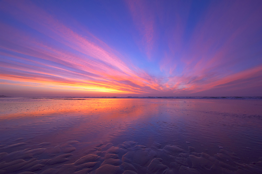 Purple and red ocean sunset on the beach at night